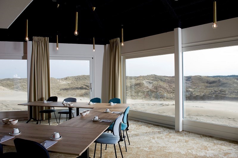 Vergaderen met uitzicht op duinen en zee