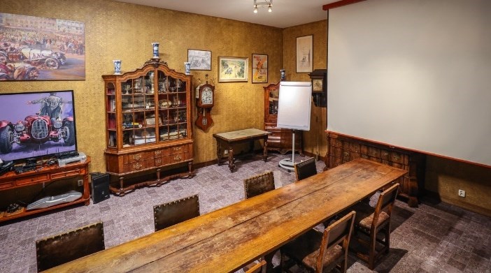 Vergaderen in een Automuseum tussen de klassieke auto's