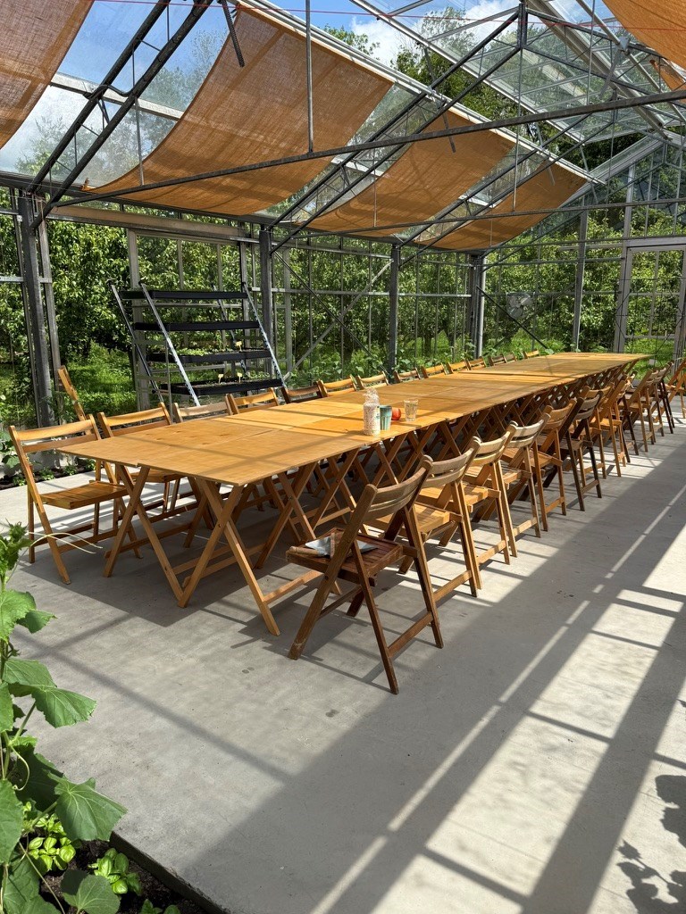 Vergaderen in een grote glazen kas tussen de perenbomen op een prachtige pluktuin