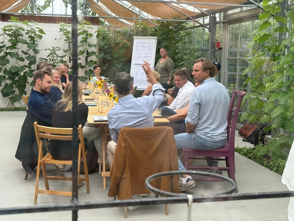 Vergaderen in een grote glazen kas tussen de perenbomen op een prachtige pluktuin