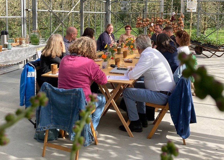 Vergaderen in een grote glazen kas tussen de perenbomen op een prachtige pluktuin